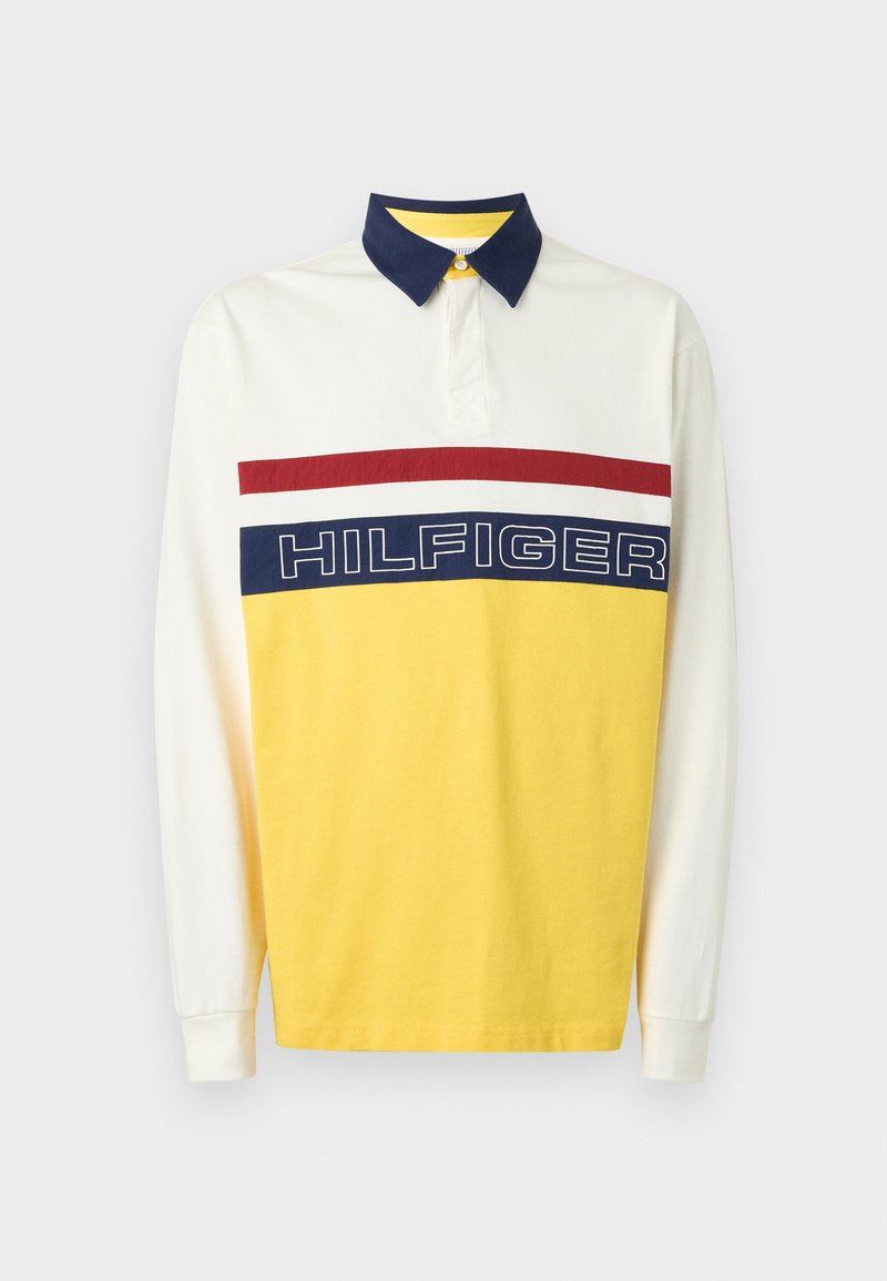 Polo à manches longues en coton blanc et jaune avec un col marine. Doté d'une bande horizontale rouge et marine proéminente avec le texte "HILFIGER".