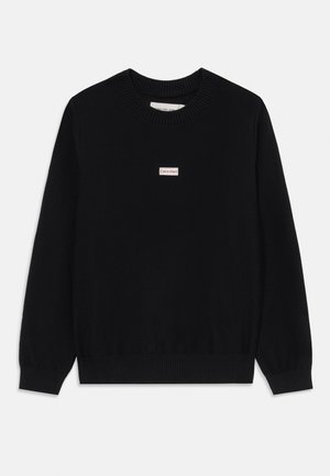 Black knitted sweater with ribbed crew neck and cuffs, featuring a small red and white Calvin Klein logo label on the chest.