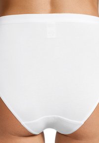 Weiße Baumwollunterwäsche mit glatter Textur, hohem Taillendesign und ohne sichtbare Nähte hinten. Das Modell hat einen einfachen, schlichten Stil.
