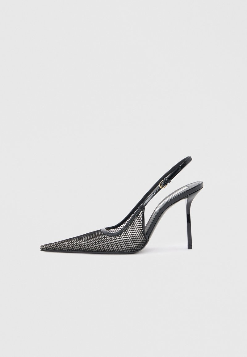 Μαύρο ντελικάτο πέδιλο με μυτερή μύτη, λεπτό τακούνι στιλέτο και ρυθμιζόμενο λουράκι στον αστράγαλο, σε λευκό φόντο.