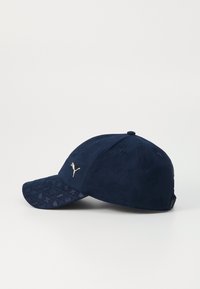 Navy blue cap with a textured fabric crown and embossed pattern on the visor; features a gold logo on the front.