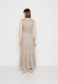 Maxikleid in Taupe mit weißem Blattmuster, ärmelloses Design, geraffte Taille, gestufter Rock und glatte Stofftextur.