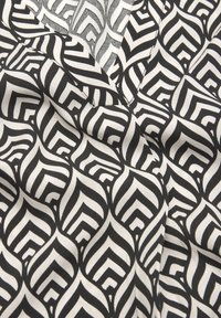 Schwarz-weißes Gewebe mit einem geometrischen Blattmuster, das abwechselnd dicke und dünne Linien aufweist, glatte Textur und hängenden Look hat.