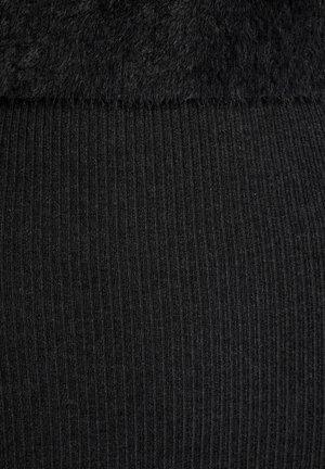 Schwarze Leggings mit einer glatten, gerippten Textur und einem flauschigen, weichen oberen Abschnitt. Insgesamt in einer einheitlichen Farbe ohne zusätzliche Muster oder Akzente.