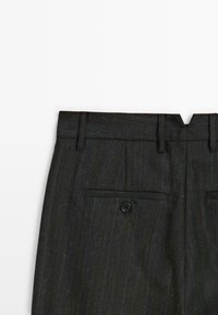 Donkergrijze pinstripe broek met riemlussen en een enkele knoopzak aan de achterkant op een witte achtergrond.