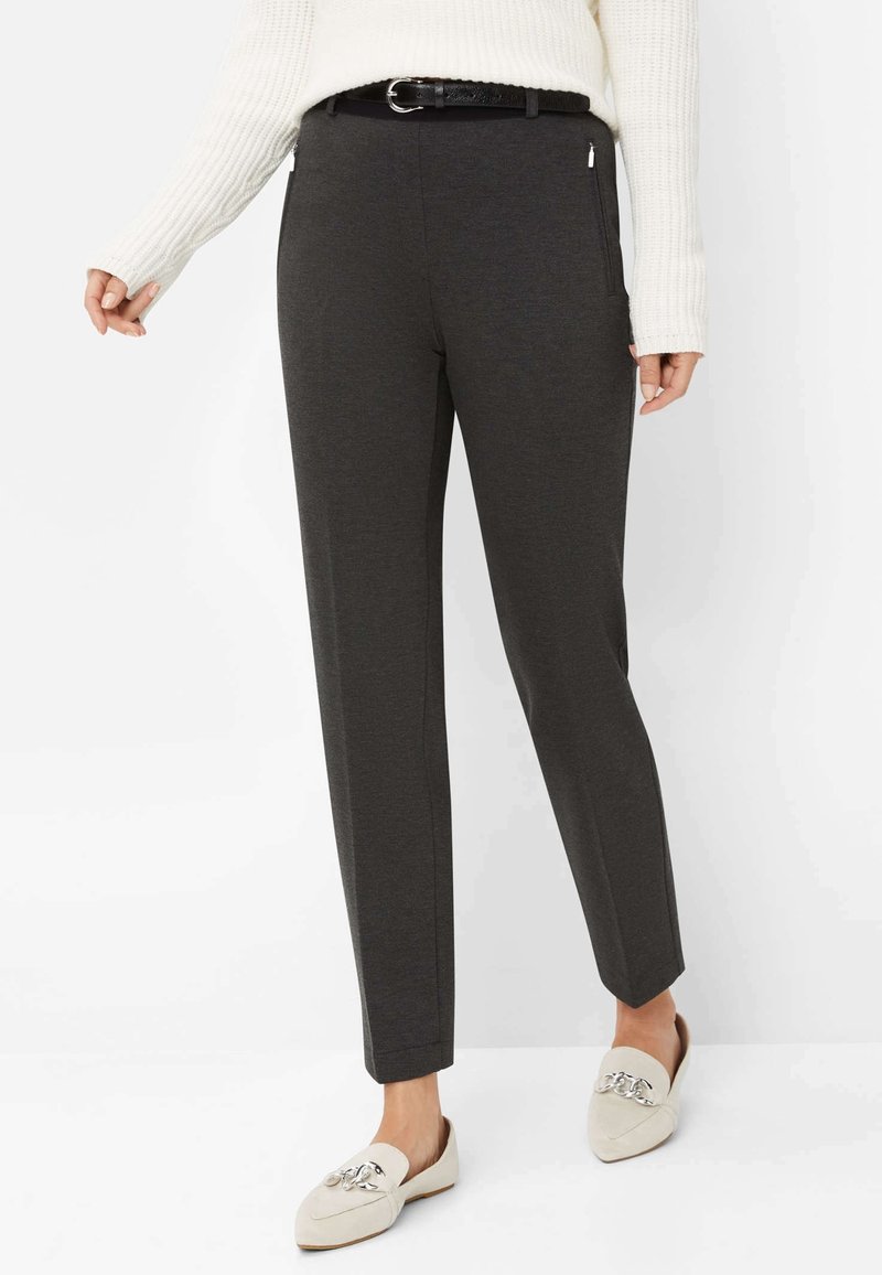 Pantalon gris foncé sur mesure avec une texture lisse et des jambes légèrement fuselées, accompagné d'une ceinture noire et de mocassins crème ornés de détails décoratifs.