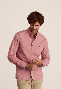 Rode button-up shirt met een geometrisch patroon in wit en blauwe accenten. Zachte stof met een kraag en lange mouwen.