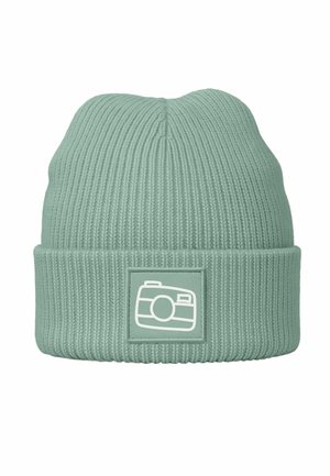 Light green ribbed knit beanie with a folded cuff, featuring a rectangular patch with a white camera icon. Soft texture and versatile design.