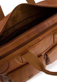 Brązowa skórzana teczka z wieloma przegrodami, w tym zamykanymi sekcjami i uchwytami na długopisy, pokazana otwarta od góry.