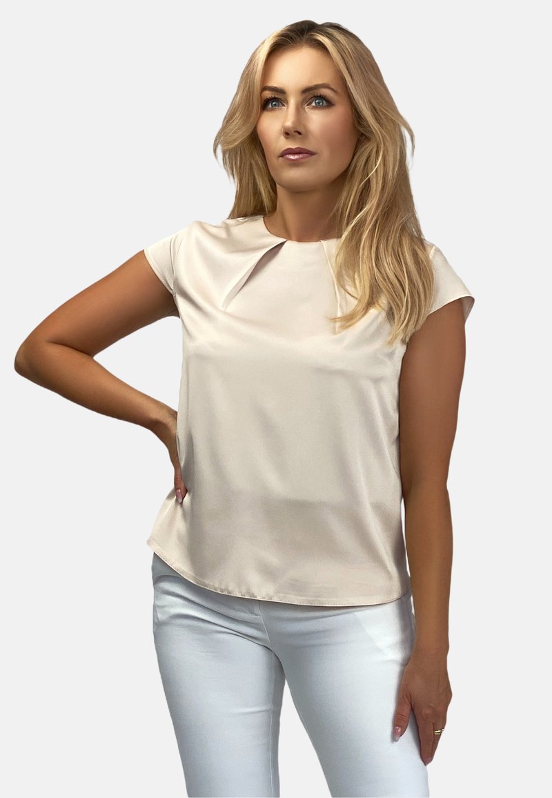 Jasnobeżowa bluzka z krótkim rękawem, z okrągłym dekoltem i subtelnymi plisami z przodu, wykonana z gładkiego, błyszczącego materiału.