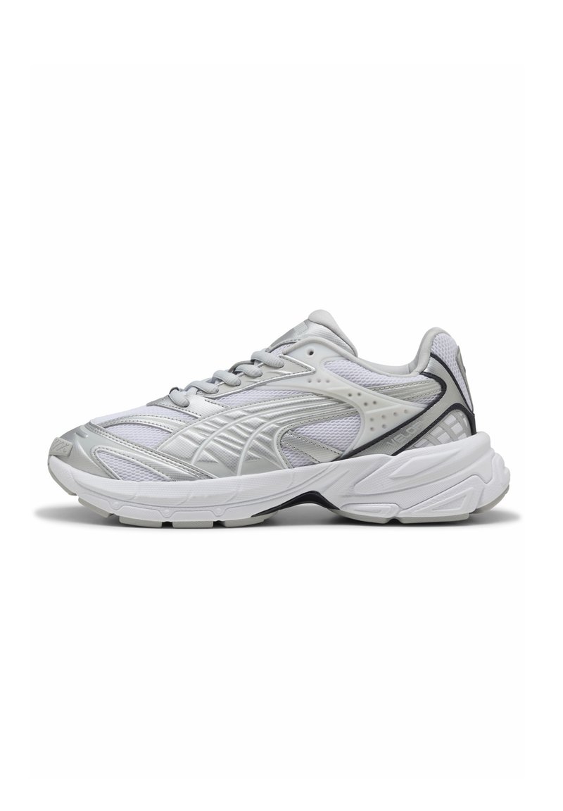 Baskets de sport blanches et argentées avec une tige en maille texturée, une semelle rembourrée et un design courbé et confortable avec des accents noirs contrastants.