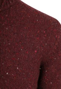 Cranberry gebreide trui met een textuurrijke afwerking. Heeft rood-witte spikkels door het hele stuk, een ronde hals en geribbelde details.