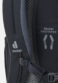 Sac à dos noir avec rembourrage en mesh portant la marque "Deuter AIRSTRIPES". Comprend des bretelles réglables et un tissu durable pour un soutien optimal.