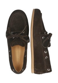 Mörkbruna mockaskor med snörning, rund tå och metallderingar. Platt sula med en strukturerad finish. Enkelt och klassiskt designkoncept.