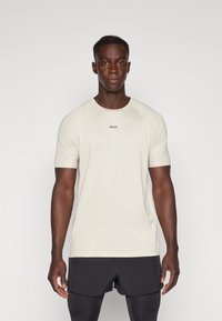 Lys beige kortermet treningsskjorte med rund hals og "BOSS" logo på brystet. Har et glatt, pustende stoff.