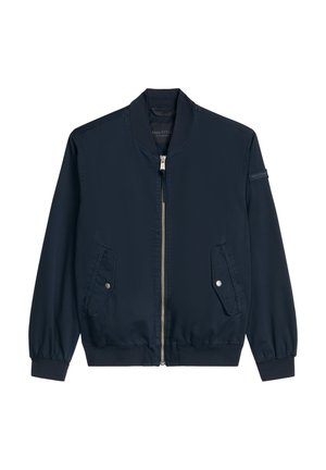 Blouson aviateur bleu marine avec fermeture éclair frontale, deux poches à rabat à bouton-pression, poignets et ourlet côtelés, et un petit patch de marque sur la manche gauche.