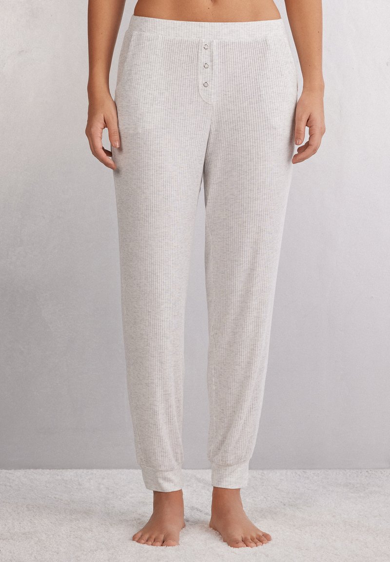 Lichtgrijze geribbelde pyjamabroek met een zachte textuur, voorzien van een knoopsluiting en elastische boorden bij de enkels, ontworpen voor comfort.