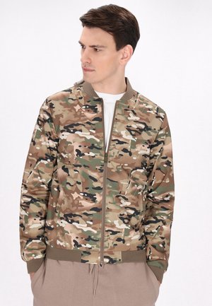 Camouflage bomberjack in tinten van groen, bruin en zwart met een ritssluiting aan de voorkant en geribde manchetten, voorzien van een schone, gladde textuur.