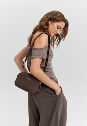 Brown leather crossbody bag with textured finish, gold-tone hardware, zip closure, and adjustable strap, displayed against a neutral background.