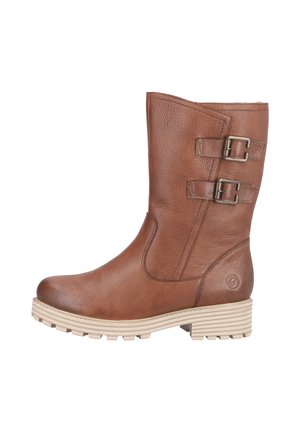 Bottine en cuir marron avec deux boucles décoratives, surface texturée et semelle épaisse de couleur claire avec des rainures horizontales.