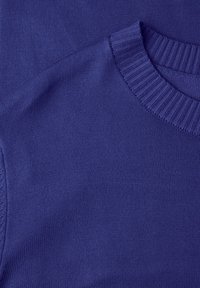 Pull violet en tricot avec un col ras du cou côtelé et une texture lisse, présentant des sections de tissu superposées mettant en valeur les détails du design.
