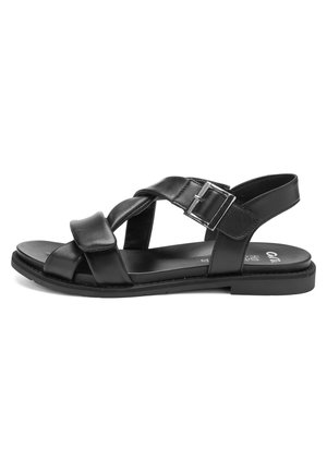 Sandale plate en cuir noir avec brides croisées, boucle métallique ajustable, et design à bout et talon ouverts, vue de côté.