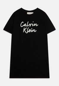 Czarna bawełniana koszulka z krótkim rękawem, okrągłym dekoltem, z białym logo "Calvin Klein" napisanym kursywą na przodzie.