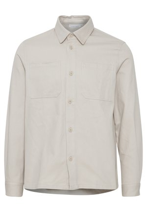 Beige long-sleeve shirt with a collared neck, two chest pockets, front buttons, and a straight hem. Made from a smooth fabric.