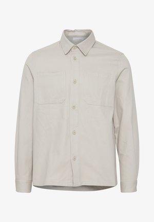 Beige long-sleeve shirt with a collared neck, two chest pockets, front buttons, and a straight hem. Made from a smooth fabric.