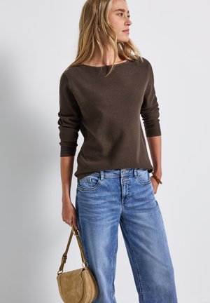 Brun stribet sweater med trekvartærmer, parret med lyseblå denimjeans. En beige skuldertaske tilføjer en neutral accent.