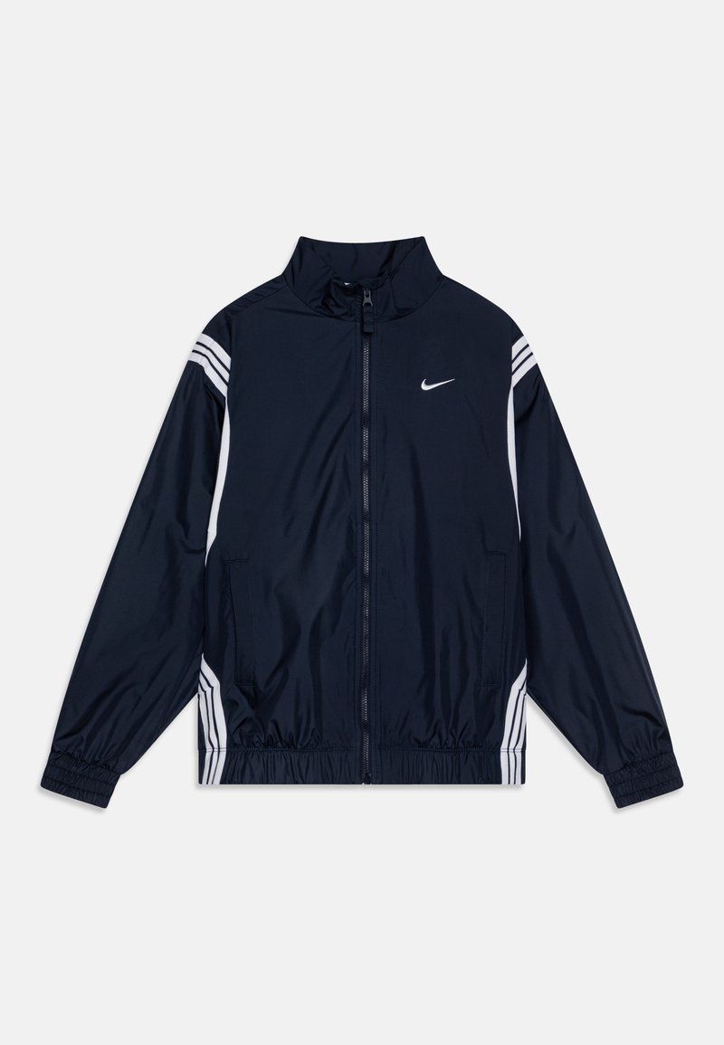 Casaco de impermeável azul marinho com fecho de zip, gola alta, punhos elásticos e riscas brancas nas laterais. Apresenta o logótipo da Nike no peito.