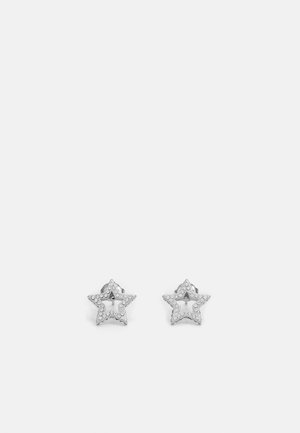 Boucles d'oreilles clous en forme d'étoile en argent avec de petits cristaux incrustés délimitant les contours de chaque étoile sur un fond clair uni.