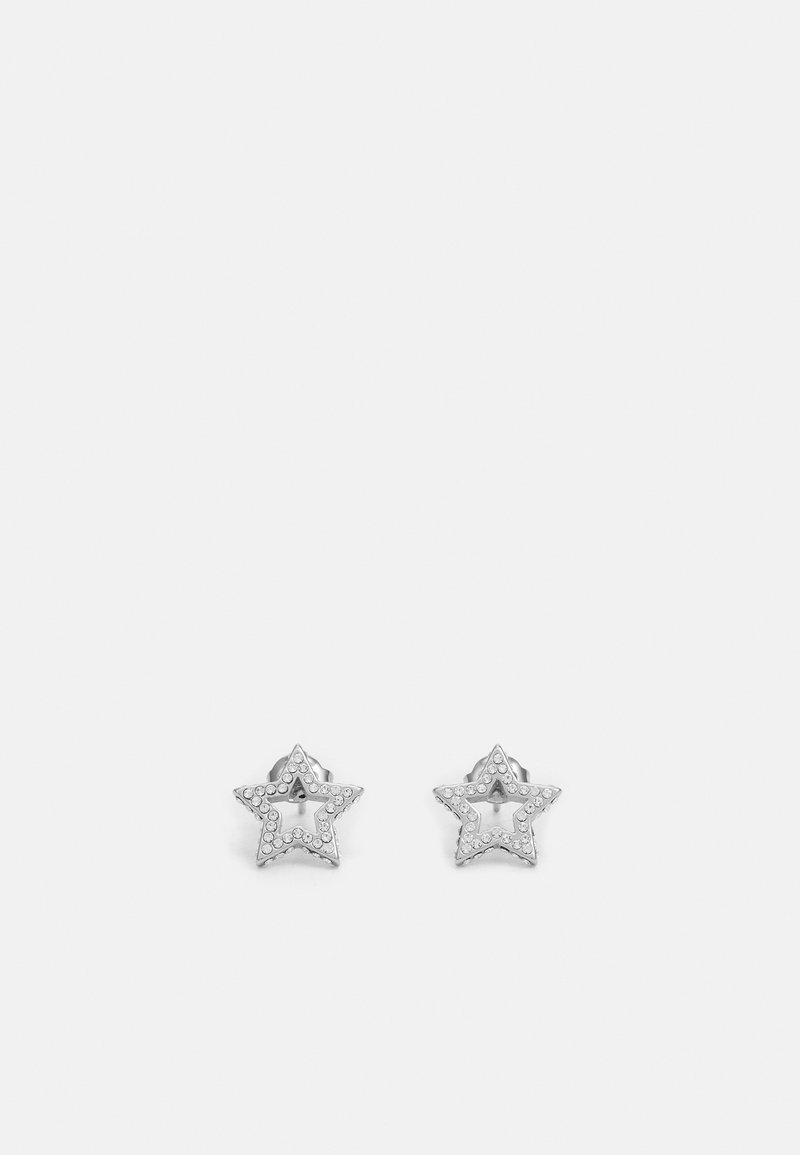 Boucles d'oreilles clous en forme d'étoile en argent avec de petits cristaux incrustés délimitant les contours de chaque étoile sur un fond clair uni.