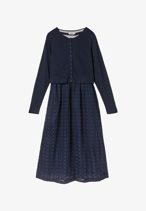 Marineblaues Kleid mit langärmligem, knöpfbarem Oberteil und einem gestuften Spitzenrock mit runden Ausschnittmustern. Texturierte Akzentdetails.