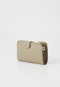 Beige läderplånbok med texturerad yta, dragkedjefack och guldfärgad hårdvara. Har en klaffstängning och en smal rektangulär form.