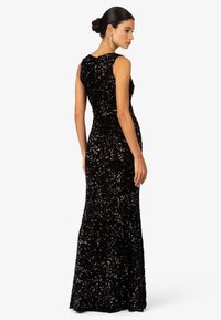 Schwarzes Abendkleid mit einer taillierten Silhouette, aus paillettenbesetztem Stoff, mit hohem Ausschnitt und einem langen, fließenden Rock.