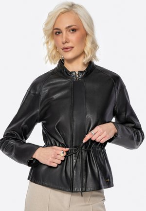 Black leather jacket with a high collar, elastic waist, and zipper closure. Features long sleeves and a smooth, shiny texture.