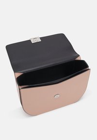 Strukturovaná kabelka z měkké růžové kůže s černým interiérem. Obsahuje stříbrnou kovovou sponu a hladké hrany. Viditelné jsou dva oddělené prostory.