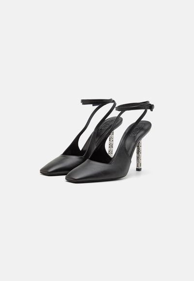 Zapatos de tacón alto de cuero negro con punta afilada y correa en el tobillo. El tacón presenta un diseño de recorte geométrico para un detalle adicional.