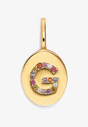Colgante de oro con una letra "G" grabada, adornada con piedras preciosas coloridas de varias formas, sobre un fondo ovalado liso.