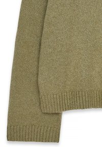 Alyvučių žalia megzta palaidinė, pasižyminti tekstūriniu audiniu, gipiūriniais rankogaliais ir apatine dalimi, laisva forma ir subtiliu dizainu.