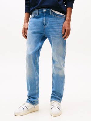 Jean en denim bleu clair à coupe droite, avec un design classique à cinq poches et un léger dégradé. Portés avec des baskets blanches.
