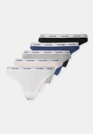 Vijf damesonderbroeken in wit, lichtroze, grijs, blauw en zwart met witte Calvin Klein merkbanden, diagonaal gestapeld.