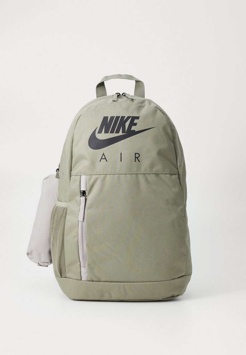 Grön nylonryggsäck med svart Nike-logotyp, zip-försedd framficka och sidoficka av mesh, med ett handtag upptill och justerbara axelremmar.