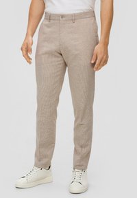 Beige geruite broek gemaakt van lichtgewicht stof, met een getailleerde pasvorm, platte voorkant, zijzakken en riemlussen, gedragen met witte sneakers.