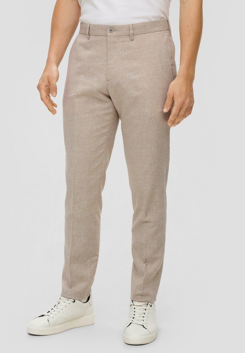Beige geruite broek gemaakt van lichtgewicht stof, met een getailleerde pasvorm, platte voorkant, zijzakken en riemlussen, gedragen met witte sneakers.