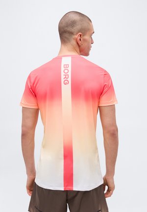 Homme aux cheveux courts portant un T-shirt de sport à dégradé rose vers blanc avec le texte « BORG » sur une bande verticale au dos, et un short foncé.