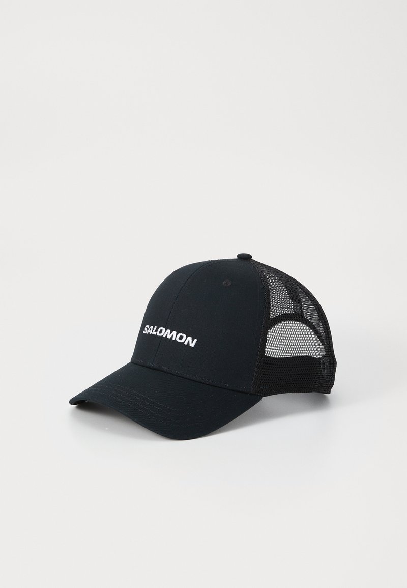 Črna kapa s ukrivljenim vizirjem, izdelana iz blaga in mrežastega materiala. Na sprednji strani se nahaja bel logotip "SALOMON". Ima nastavljiv trak na hrbtni strani.