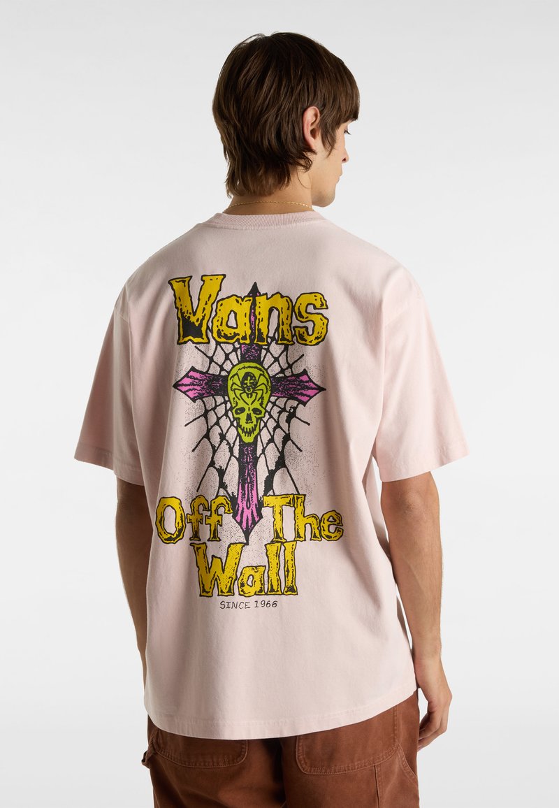 Rosa Baumwoll-T-Shirt mit einem großen Grafikdesign, das einen Totenkopf mit gekreuzten Knochen zeigt, umrandet in Gelb und Pink. Der Text "Vans Off The Wall" ist ebenfalls enthalten.