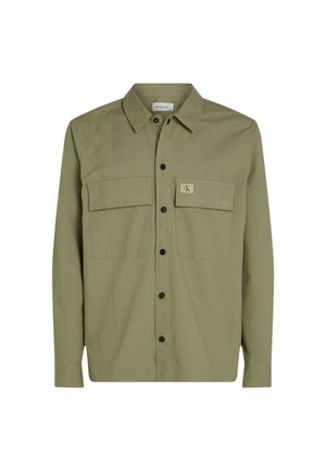 Camisa verde oliva de botones con dos bolsillos en el pecho, botones negros y una etiqueta. Hecha de una tela suave y ligera.